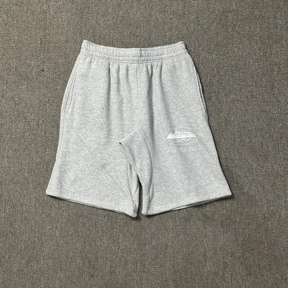 Corteiz light grey marl cotton jogger shorts laid flat, showing white logo and yacht graphic print on the left thigh