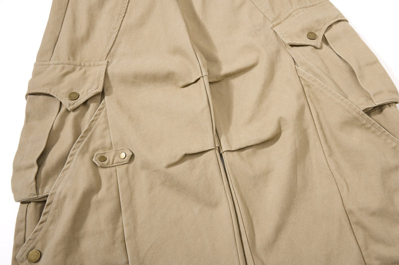 Close-up of khaki cargo pant leg with flap pockets and snap tab details