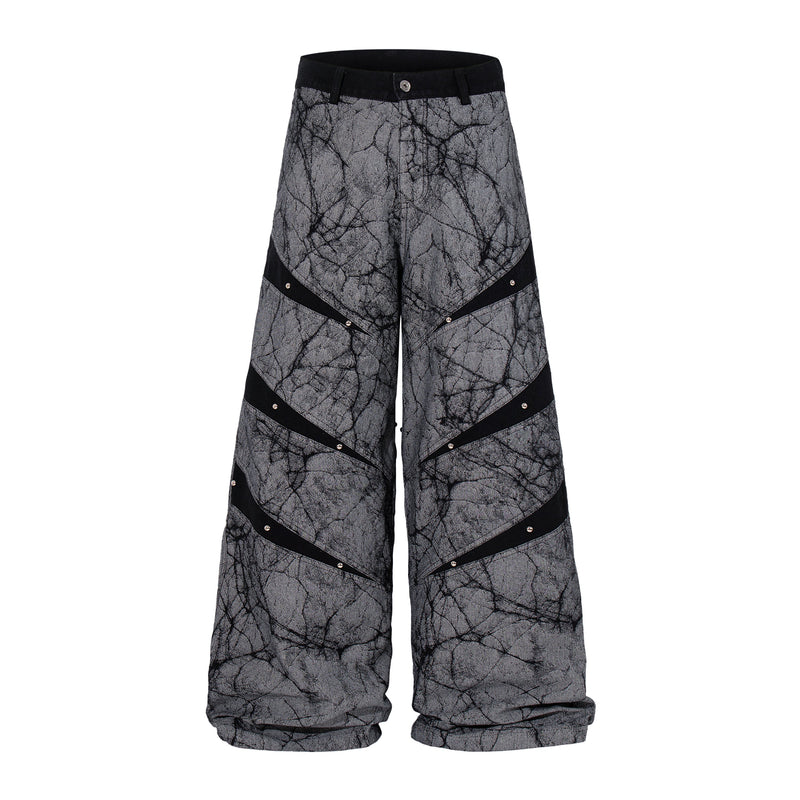 Front view of gray wide-leg denim pants with black panel stripes and rivet details