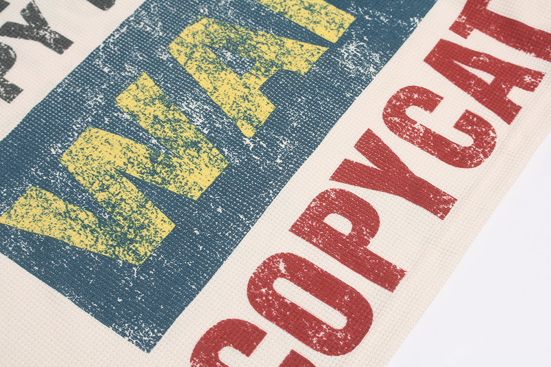 Close-up of blue graphic block with yellow text and red lettering on shirt