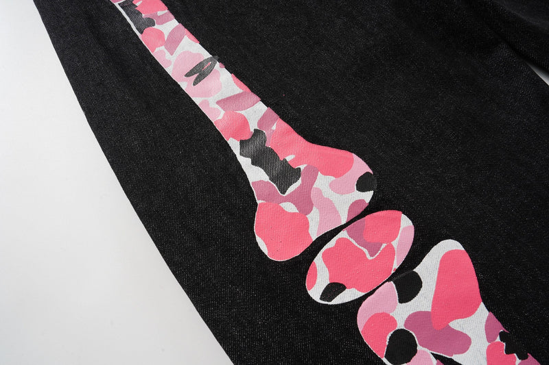 Pink camouflage skeleton leg print running down black denim pants