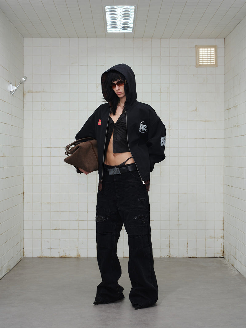 Full-body view of model wearing black plaid-lined zip hoodie with hood up and front graphics