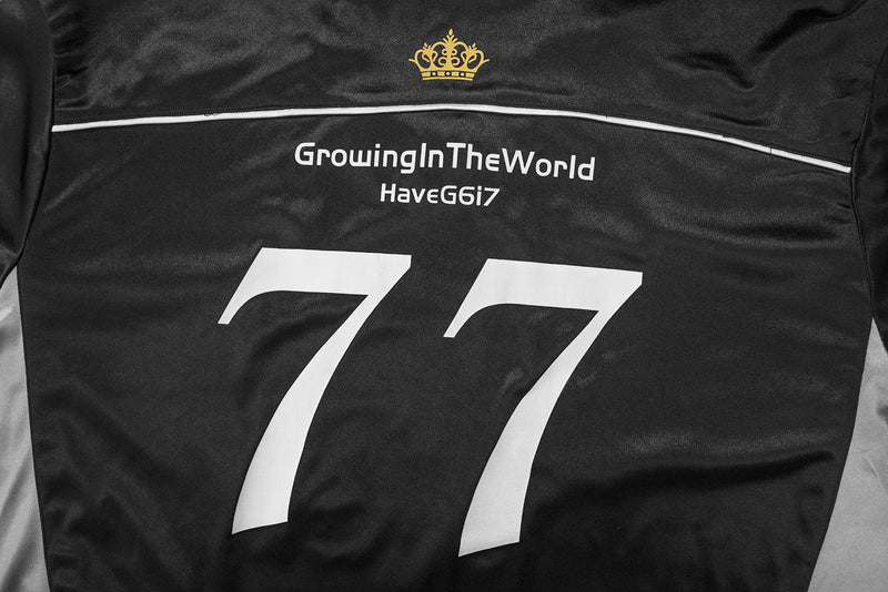 Back upper panel close-up of black jersey with gold crown, text, and large white 77