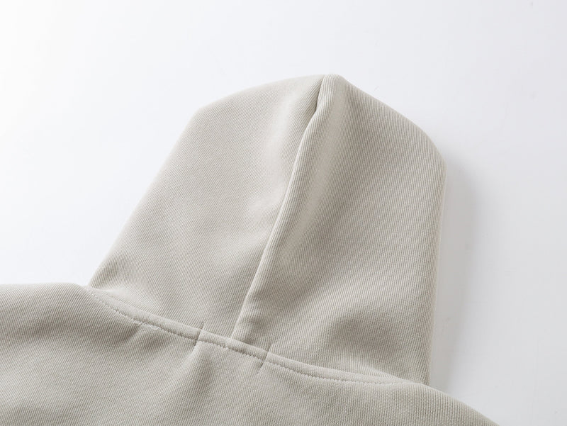 Close-up of beige hoodie hood showing smooth knit fabric and center seam