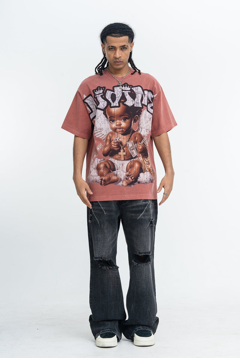 Oversized faded pink graphic T-shirt with angel baby print, styled with distressed black jeans on a male model