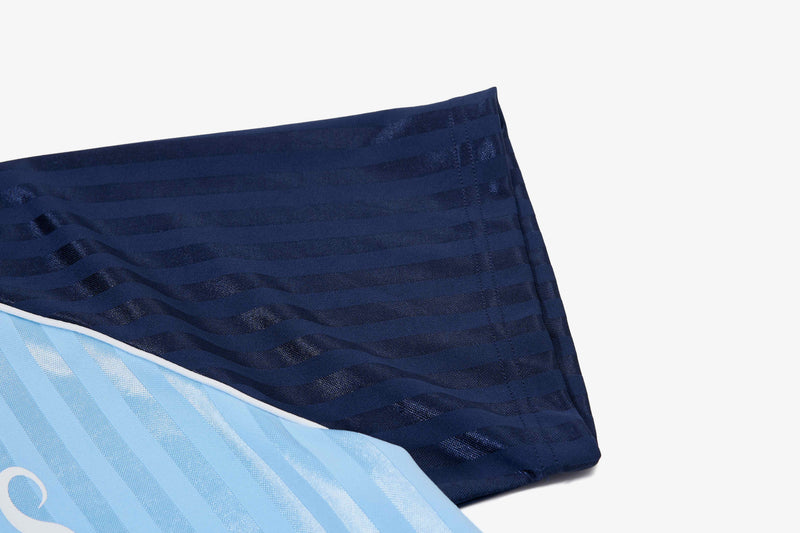 Close-up of navy and light blue striped football jersey fabric with textured mesh detailing and white piping