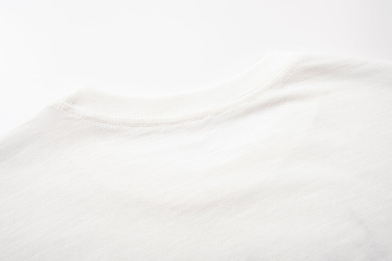 Close-up of a white crew neck T-shirt collar with subtle abstract sketch-style texture and clean streetwear look