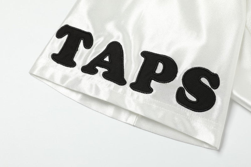 White varsity mesh jersey with bold black TAPS lettering on the sleeve, featuring a sporty football tee style