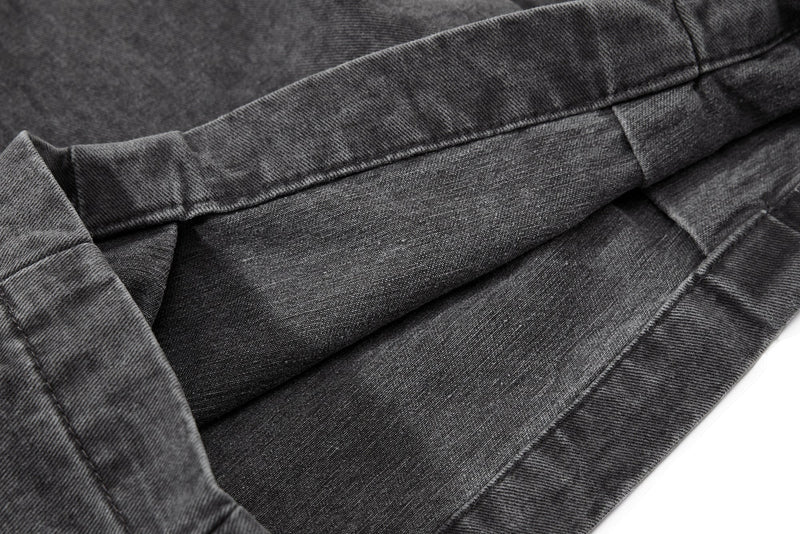 Close-up of washed black denim-like fabric and stitched seam detail
