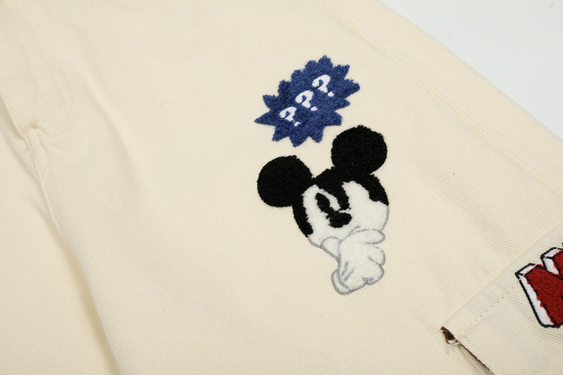 Close-up of Mickey-style face patch on cream cargo pants