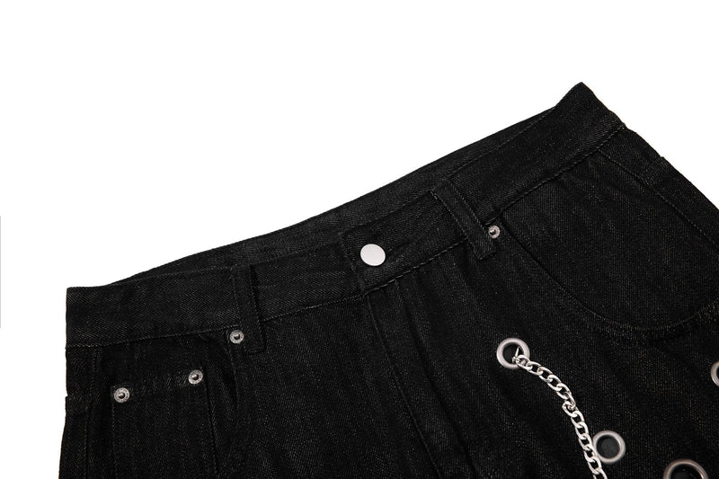 Close-up of black denim waistband with belt loop, snap button, and front pocket edge