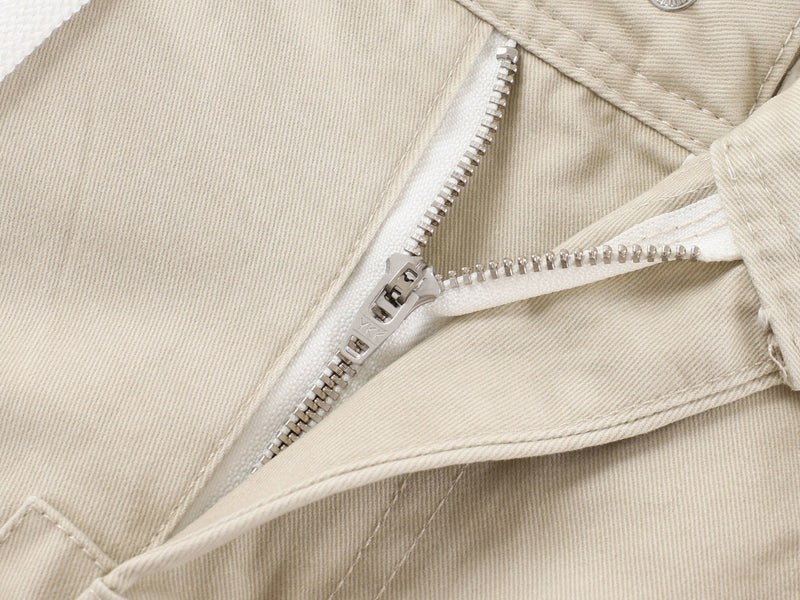 Close-up of beige cargo pants zipper fly and waistband seam detail