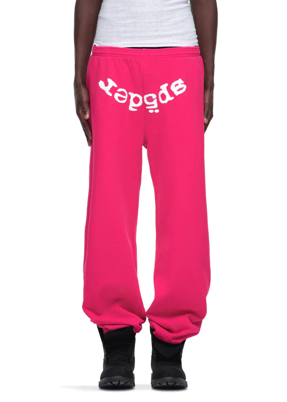 Someone rocks the Sp5der Sweatpants – Unisex Pink Cotton Sweatpants with a front logo print, teamed with a white top and black shoes—a perfect pick for bold pink streetwear fans.