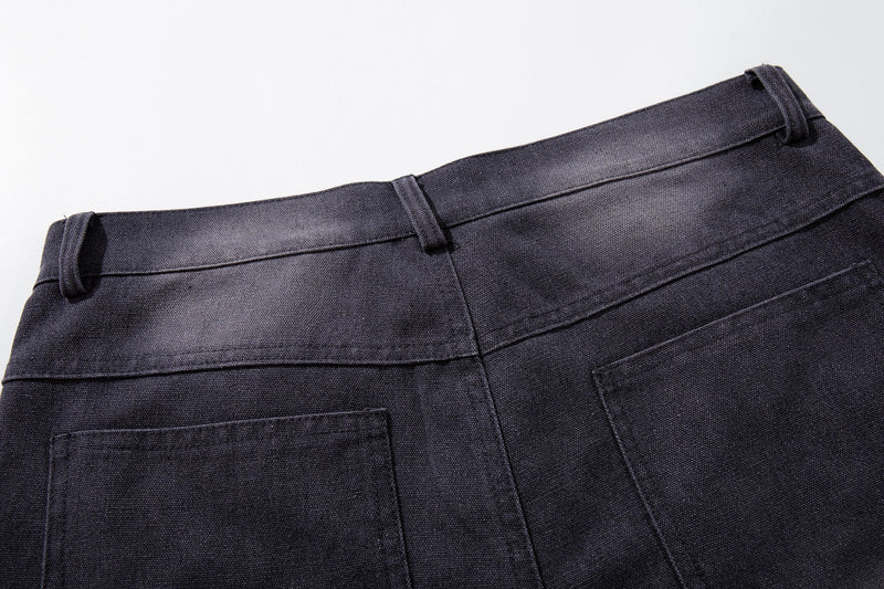 Close-up of the back waistband and belt loops on dark denim shorts
