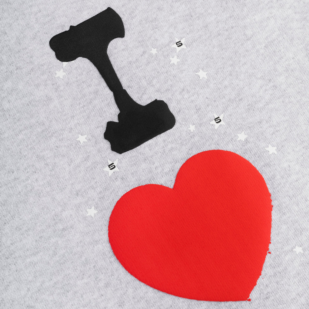 A graphic on a gray background shows a judge’s gavel above a large red heart with white stars, in the bold streetwear style of 100% Cotton Sp5der Sweatpants for Men—Light Grey Jogger Pants with “I Love Sp5der” Graphic and relaxed fit.