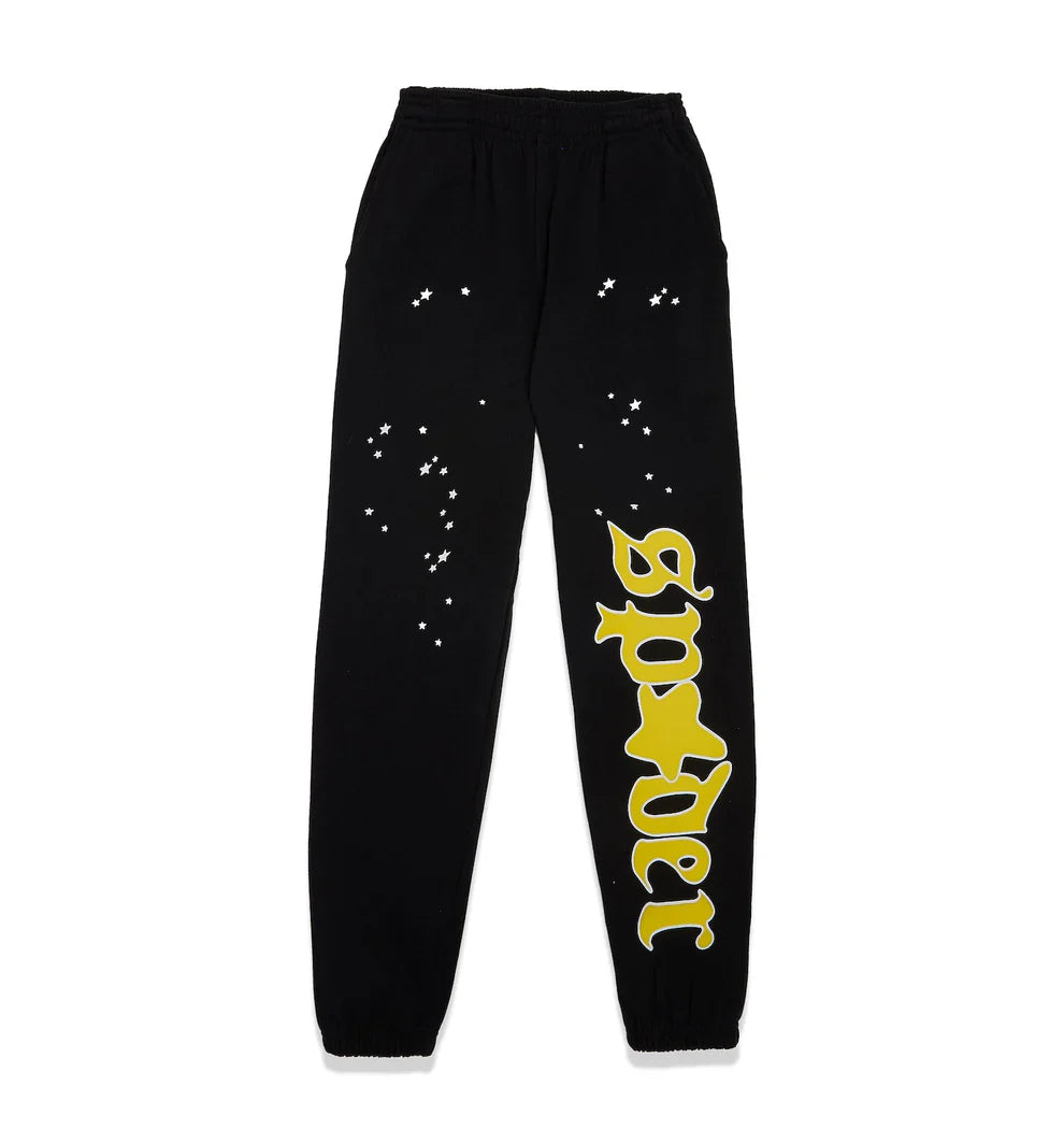 The 100% Cotton Sp5der Sweatpants for Men are black streetwear jogger pants with a relaxed fit, white star-like dots, and a bold yellow Sp5der logo graphic running vertically down one leg.