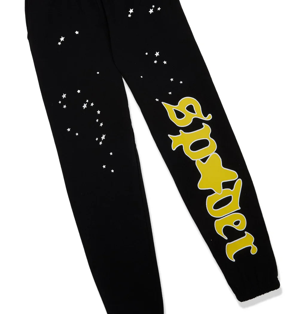 100% Cotton Sp5der Sweatpants for Men—Black streetwear jogger pants with a relaxed fit and bold yellow logo graphic on one leg, featuring scattered white stars for standout style.