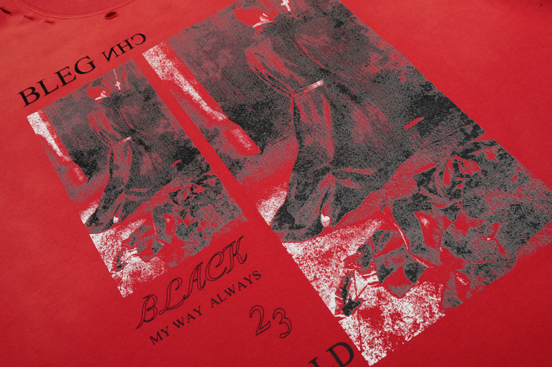 Close-up of a vintage red graphic tee with distressed black-and-white portrait print and bold streetwear text details