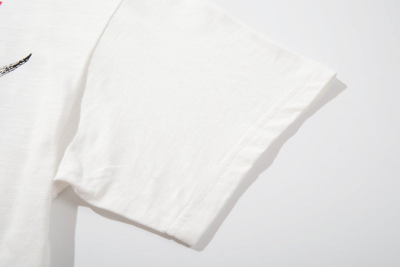 White vintage graphic tee sleeve with soft cotton texture and subtle black band poster print detail