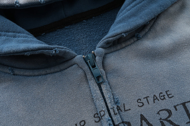 Close-up of blue zipper and printed chest graphic on vintage wash hoodie