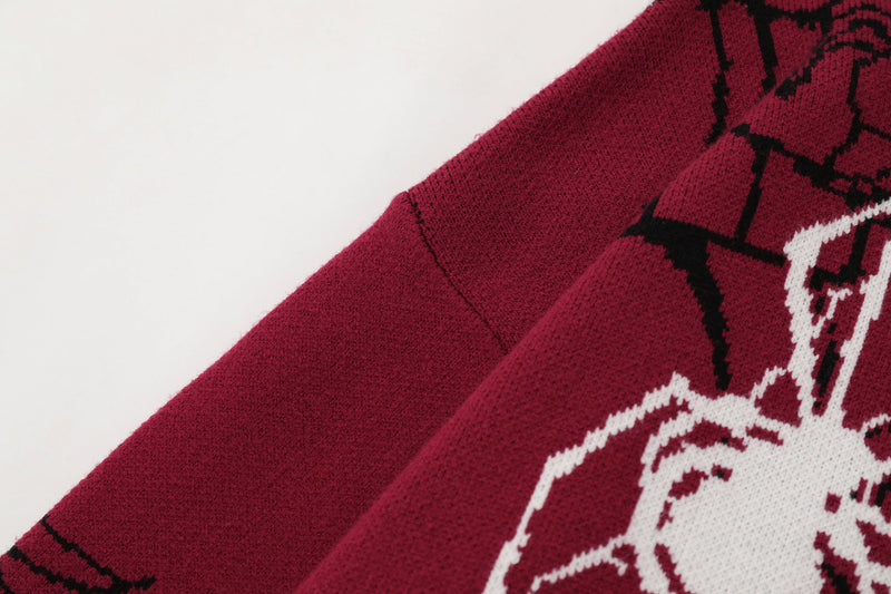 Close-up of burgundy knit sleeve and front graphic detail on spiderweb zip hoodie