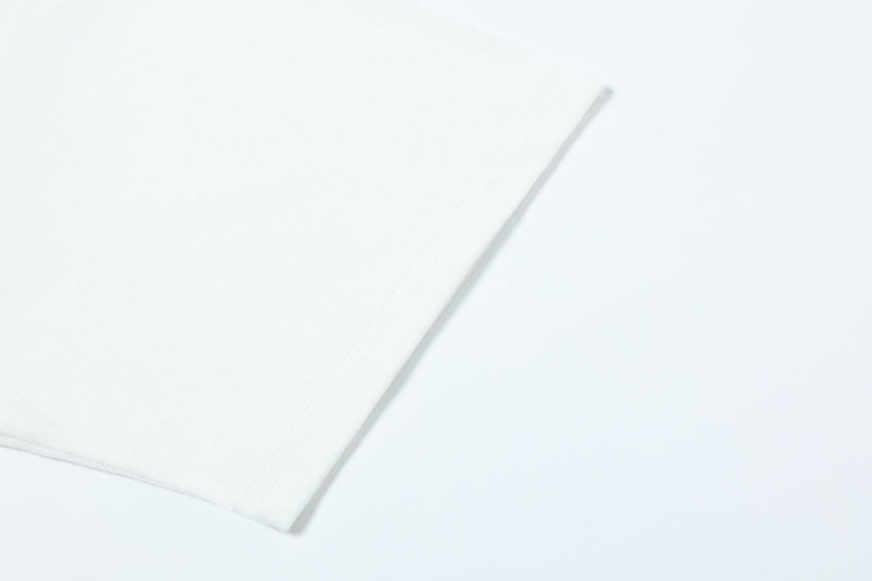 Close-up of a white graphic tee sleeve on a clean background, showing soft cotton texture and minimalist streetwear style