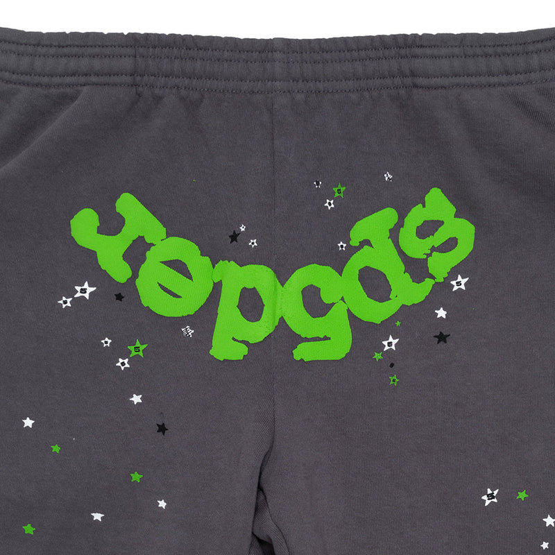 The 100% Cotton Sp5der Sweatpants for Men are dark grey jogger pants featuring a relaxed fit, elastic waistband, and bold green logo graphic surrounded by small white, black, and green stars.