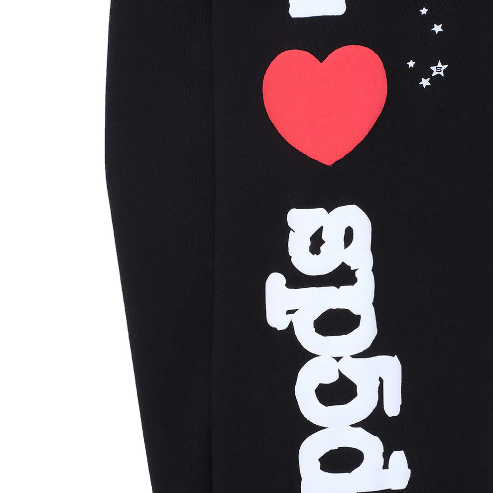 The 100% Cotton Sp5der Sweatpants are unisex black jogger pants featuring a bold “I Love Sp5der” graphic and small star accents, with vertically arranged letters for a trendy, relaxed-fit streetwear look.