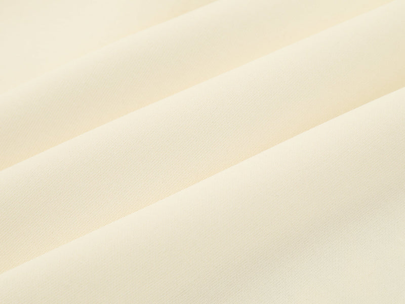 Close-up of cream jersey plain fabric with subtle woven texture