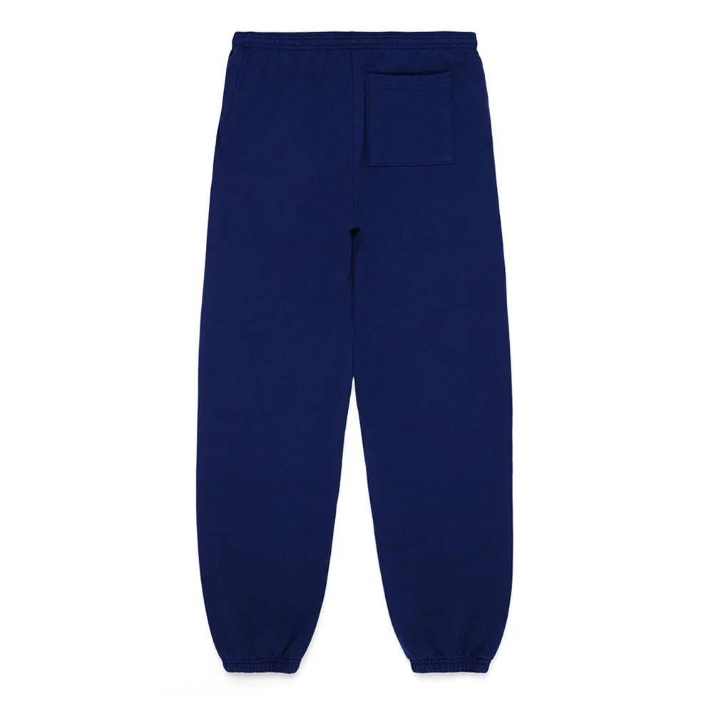 100% cotton Sp5der sweatpants in navy blue, unisex relaxed-fit jogger pants with pink logo and star graphics, featuring an elastic waistband, ankle cuffs, and a back right patch pocket—laid flat on a white background.