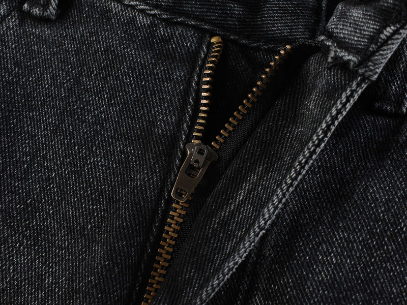 Close-up of black denim zipper and seam detail