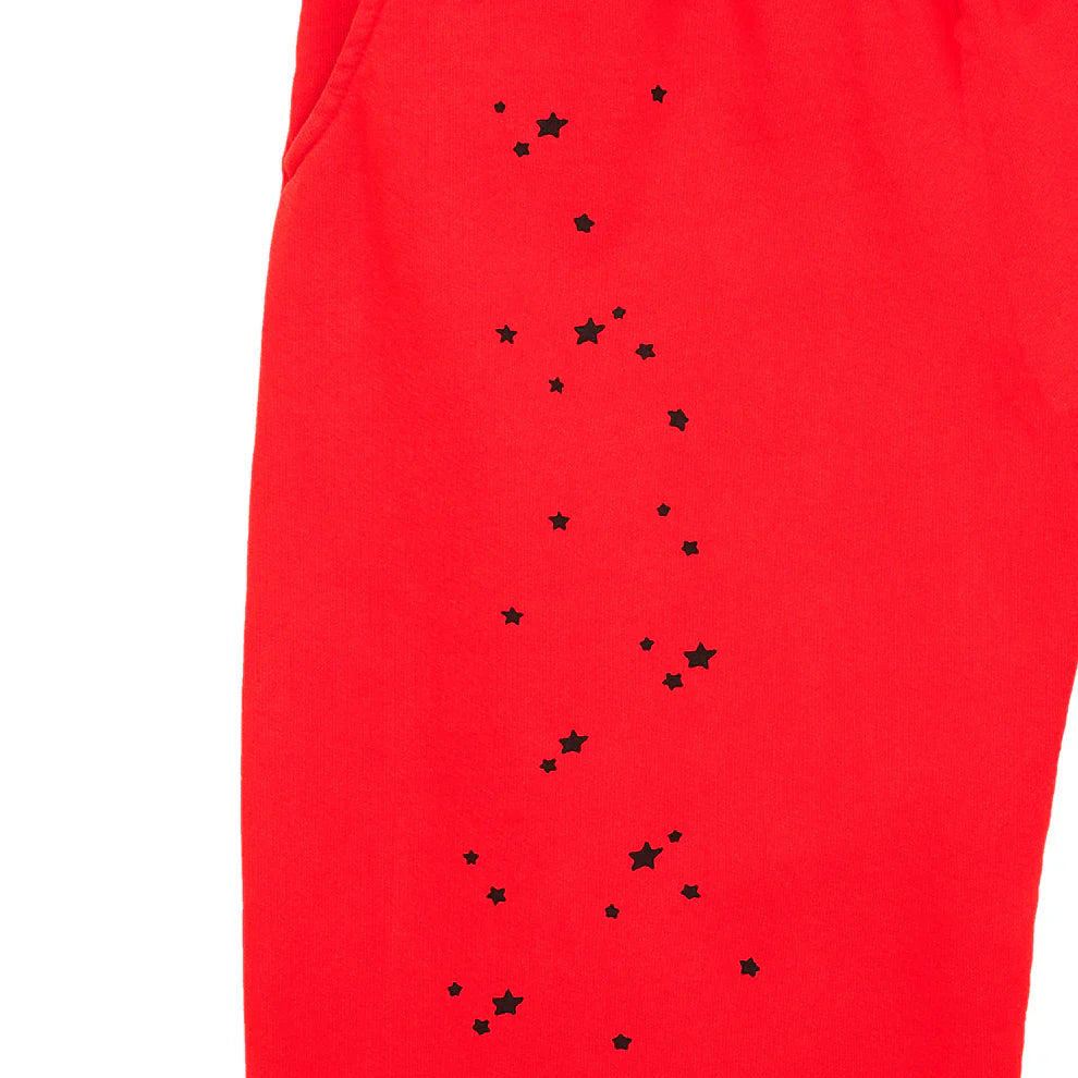 Close-up of 100% Cotton Sp5der Sweatpants: unisex red jogger pants featuring black logo and star graphics, with a partially visible side pocket—perfect for relaxed streetwear looks.