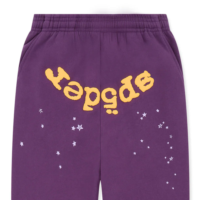 Unisex 100% cotton Sp5der sweatpants in purple, featuring a relaxed fit, elastic waistband, large yellow logo across the back, and white star graphics—stylish streetwear jogger pants inspired by Sp5der.