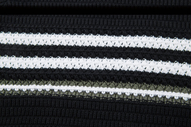 Close-up of black and white striped knit with olive accent stripe