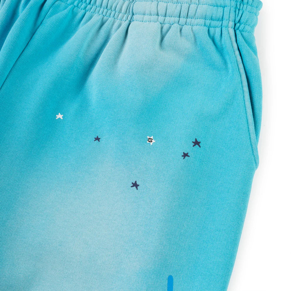 Close-up of 100% Cotton Sp5der Sweatpants—unisex blue jogger pants with an elastic waistband, side pocket, relaxed fit, spider web graphic, and star details for a perfect streetwear style.