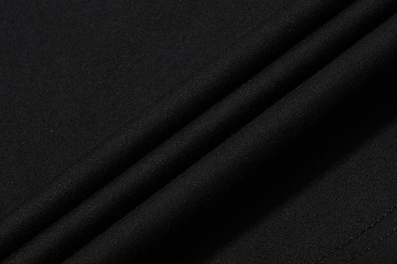 Close-up of black textured polo fabric with diagonal folds and a sleek streetwear look
