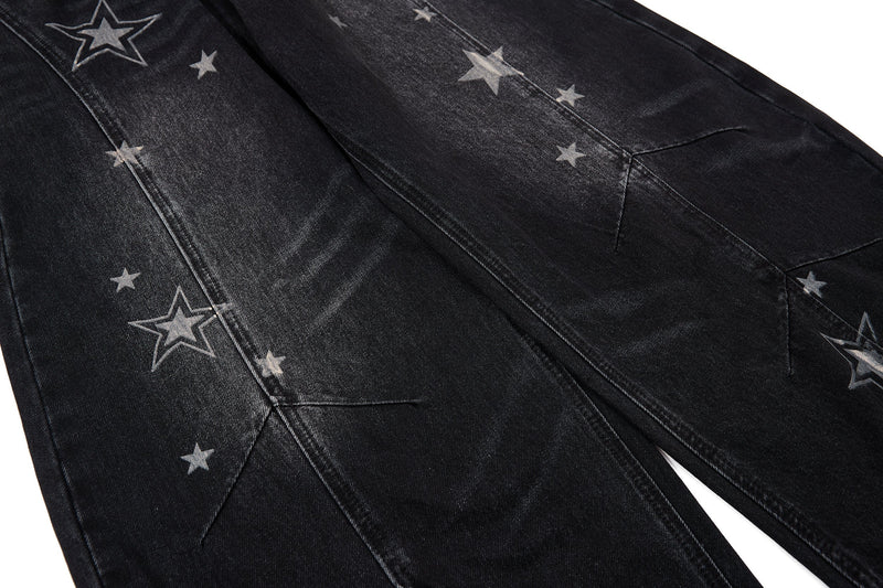 Close-up of black washed denim with scattered star graphics and seam lines