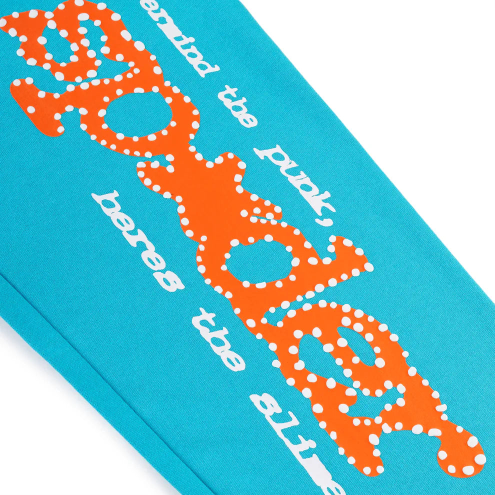 Close-up of 100% Cotton Sp5der Sweatpants—Unisex teal jogger pants with a bold orange dotted logo and relaxed fit, perfect for unique streetwear style.