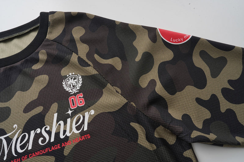 Upper chest of camo long sleeve jersey with white Mershier graphic and red 06 patch