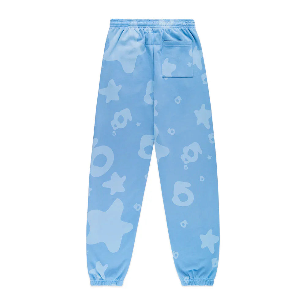 The Sp5der Light Blue All-Over Print Sweatpants are unisex streetwear joggers made from 100% cotton, featuring an elastic waistband and cuffs, playful abstract shapes in lighter blue, stars, ovals, and a back right patch pocket.