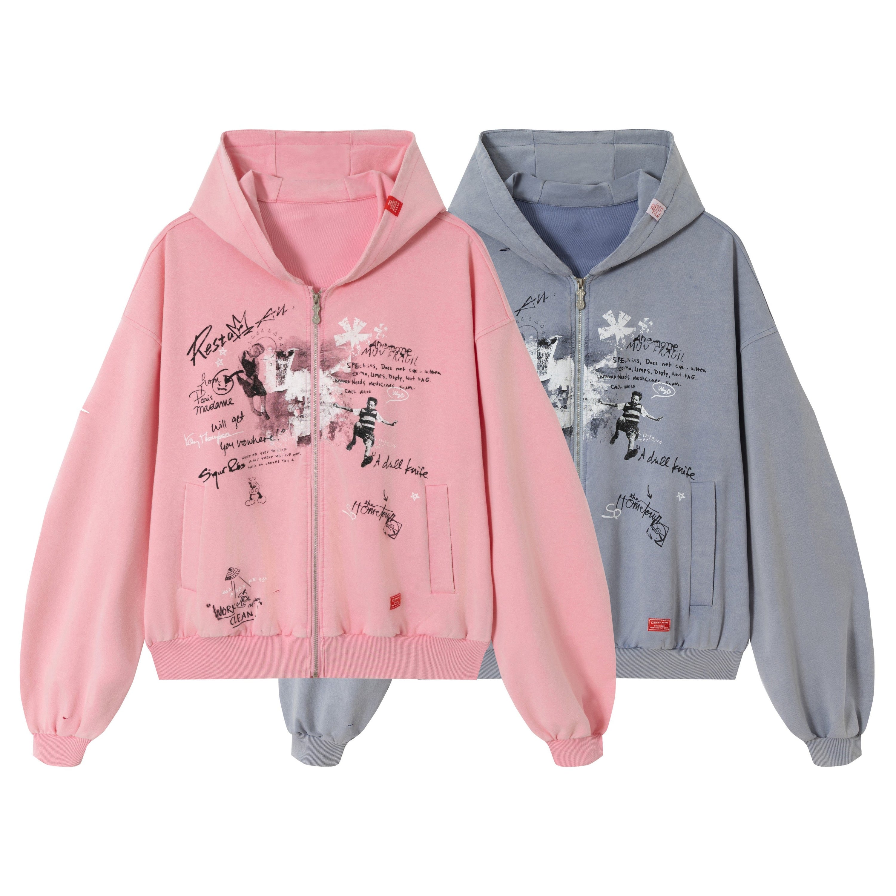 Pink and slate blue oversized zip hoodies with handwritten graffiti-style graphic prints displayed side by side on white back