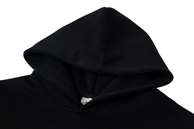 Close-up of plain black hood with soft fabric texture and layered opening