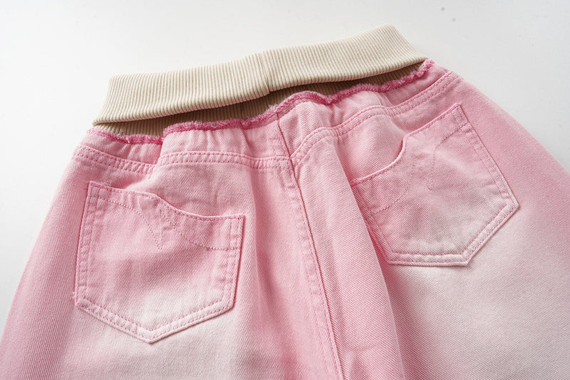 Close-up of the back waist and patch pockets on pink washed wide-leg jeans