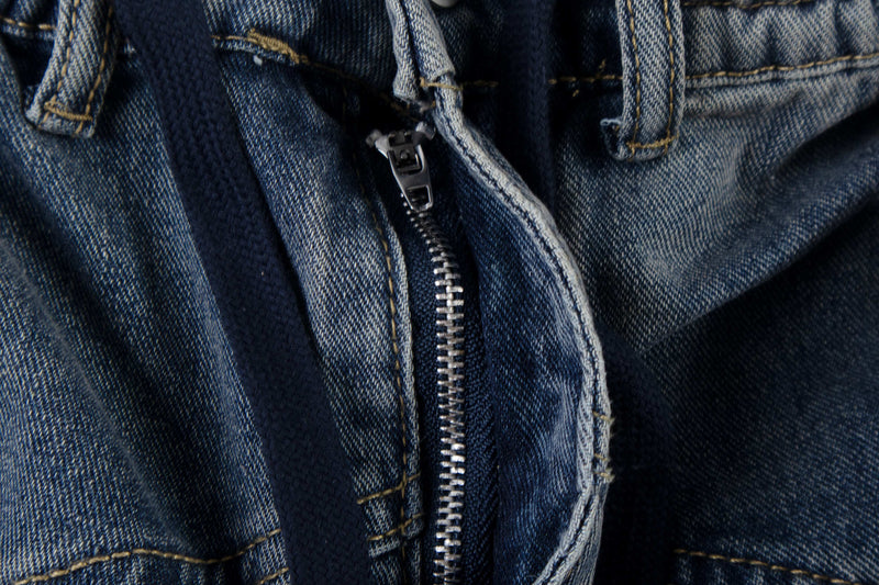 Close-up of blue denim zipper fly with plaid layers and visible stitching