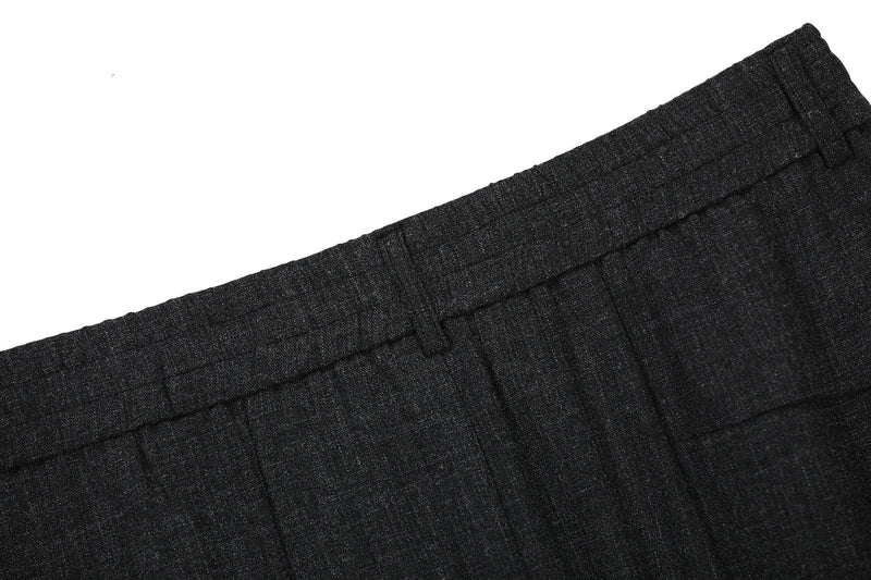Close-up of black waistband and upper front pleats on textured pants