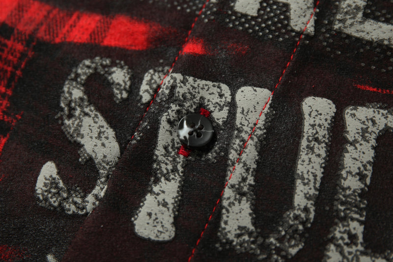 Close-up of black button and distressed lettering on the shirt's printed front design