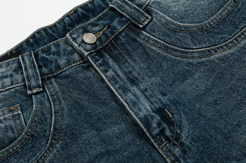 Close-up of front waist, button fly, and seam detail on denim shorts