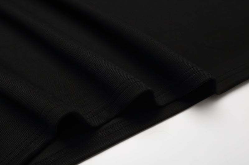 Close-up of black ribbed cotton fabric with subtle texture and folded edge for a gothic polo shirt