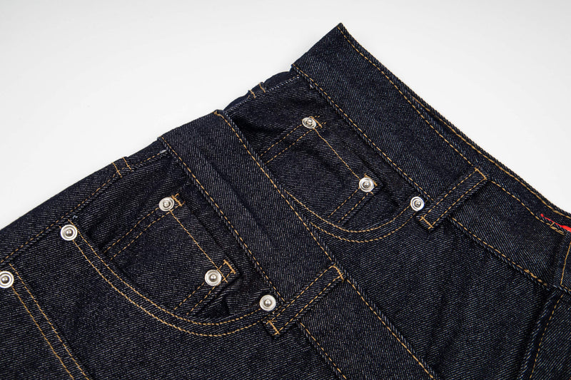 Close-up of waistband and pocket details on dark wash denim shorts