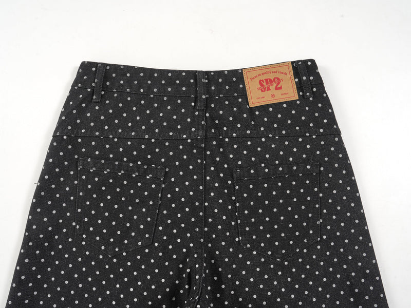 Upper back view of black polka-dot denim pants showing waistband, back pockets, and brand patch